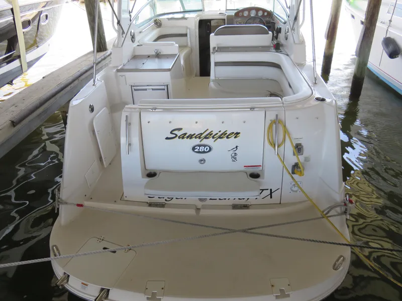 Slide: The Image of 2008 Rinker 280 Express Cruiser docked, rear view showing seating and deck area. - 2