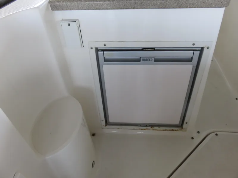 Slide: The Image of 2008 Rinker 280 Express Cruiser interior with built-in fridge. - 23