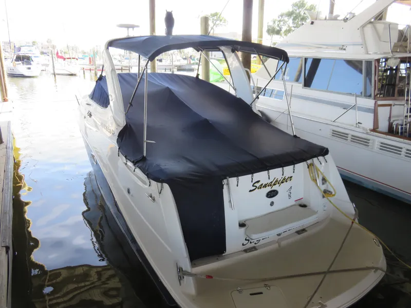 Slide: The Image of 2008 Rinker 280 Express Cruiser docked, covered with a navy blue canopy. - 28