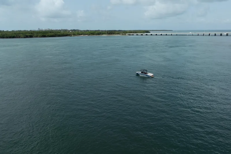 Slide: The Image of 2019 Nautique Super Air Nautique GS24 on open water near a bridge. - 24