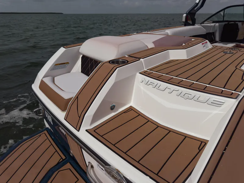 Slide: The Image of 2019 Nautique Super Air Nautique GS24 boat with teak deck, on calm water. - 27