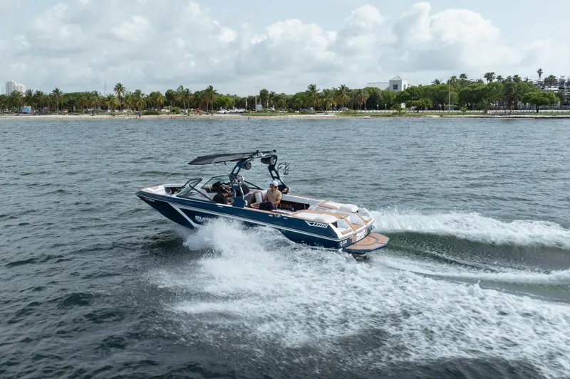 Slide: The Image of 2019 Nautique Super Air Nautique GS24 cruising on a scenic lake. - 3