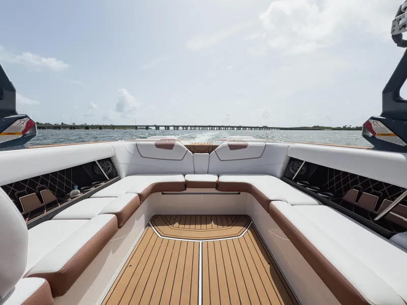 Slide: The Image of 2019 Nautique Super Air Nautique GS24 boat interior with spacious seating and scenic water view. - 36