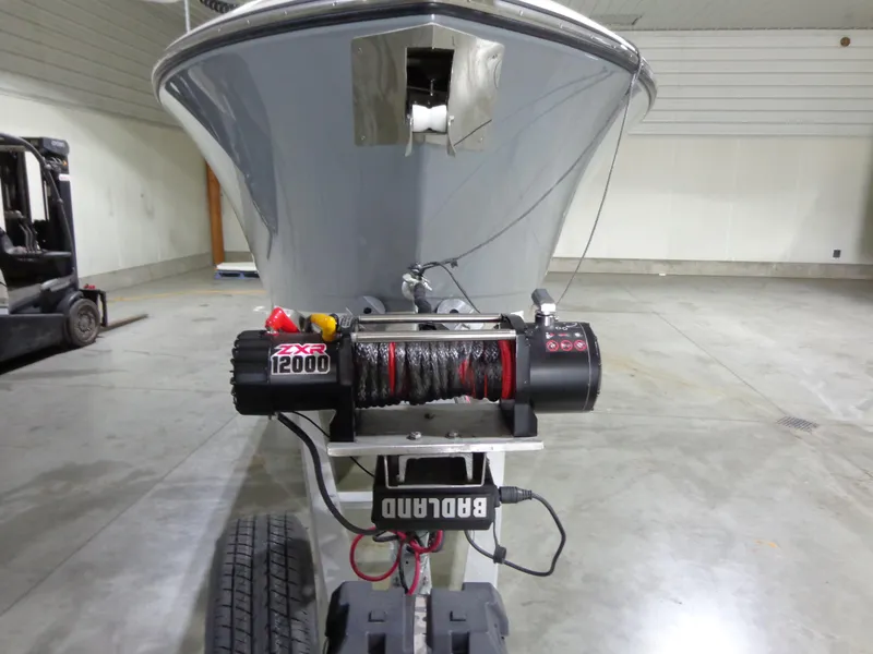 Slide: The Image of 2023 Cobia 280 Center Console boat on trailer with ZXR 12000 winch in a garage. - 18