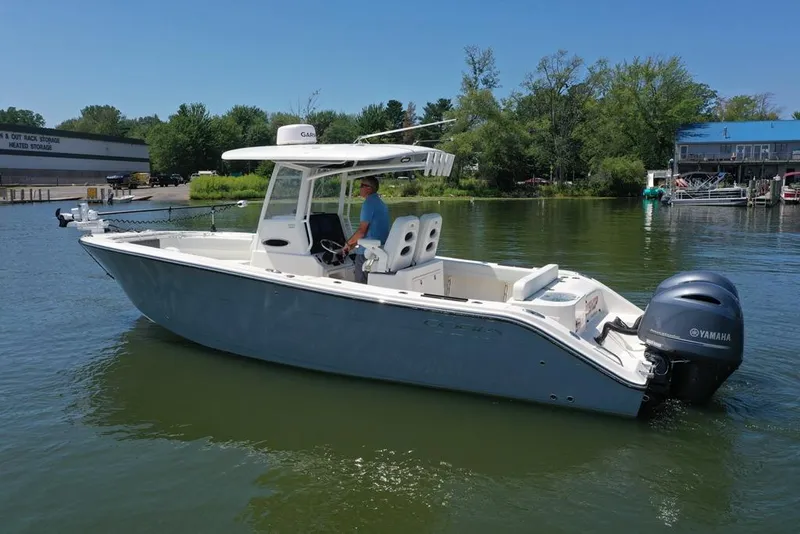 Slide: The Image of 2023 Cobia 280 Center Console boat on calm water with Yamaha engine. - 26