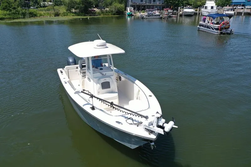Slide: The Image of 2023 Cobia 280 Center Console boat on calm water, featuring Garmin equipment. - 30