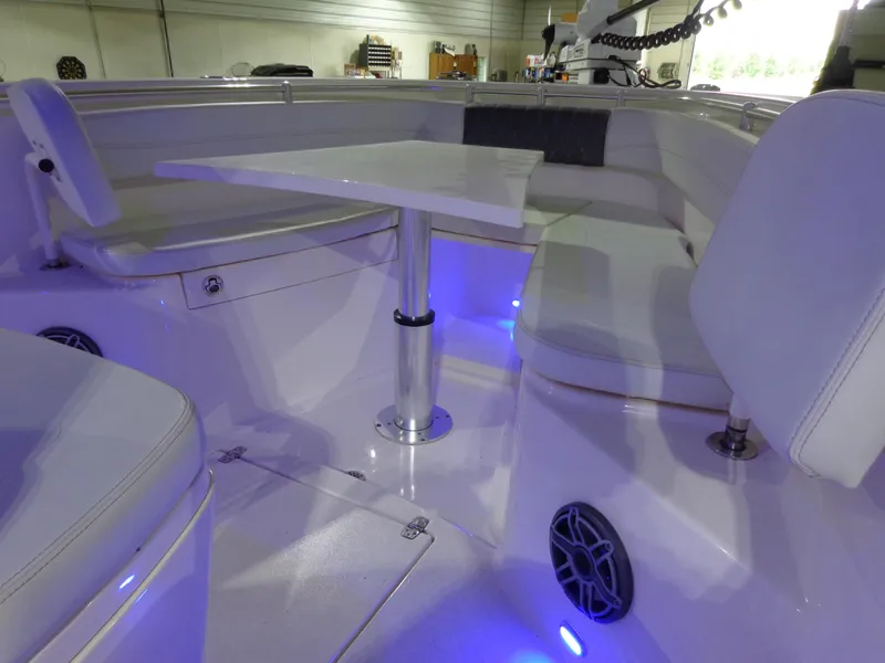 Slide: The Image of 2023 Cobia 280 Center Console interior with seating, table, and blue LED lighting. - 37