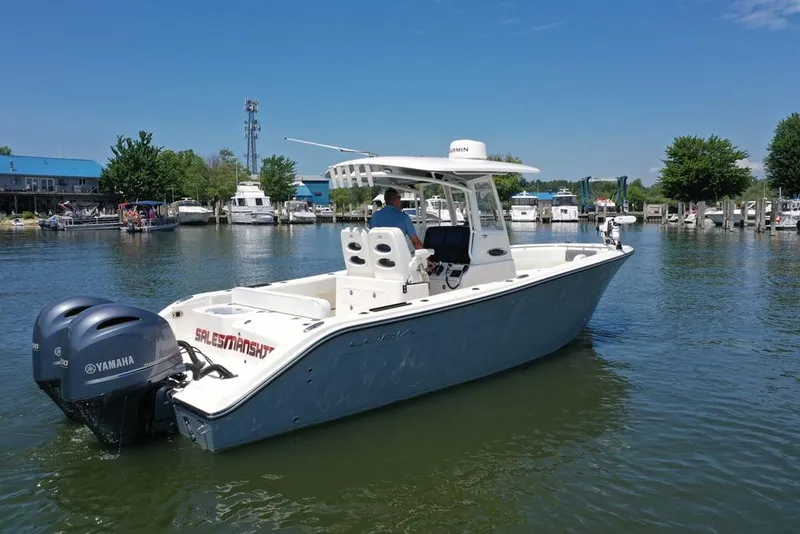 Slide: The Image of 2023 Cobia 280 Center Console boat with Yamaha engines in a marina setting. - 39