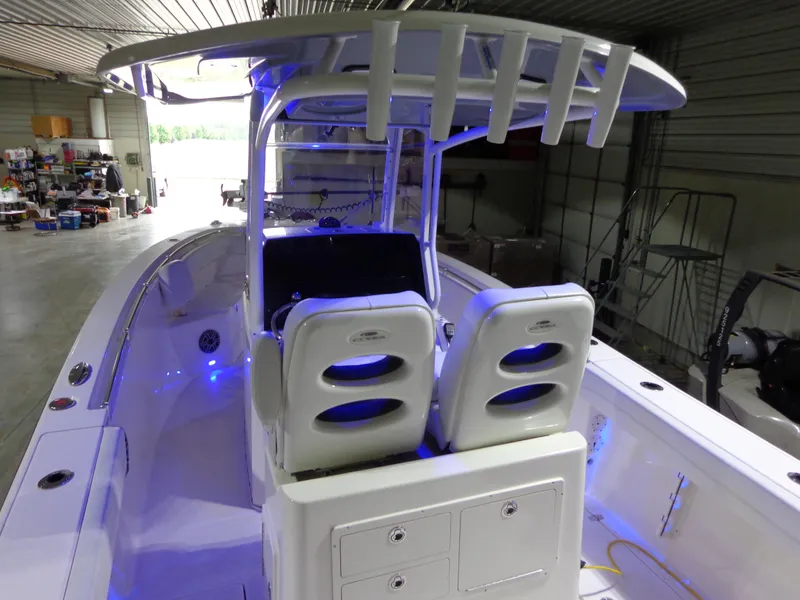 Slide: The Image of 2023 Cobia 280 Center Console boat with illuminated interior in a storage facility. - 5
