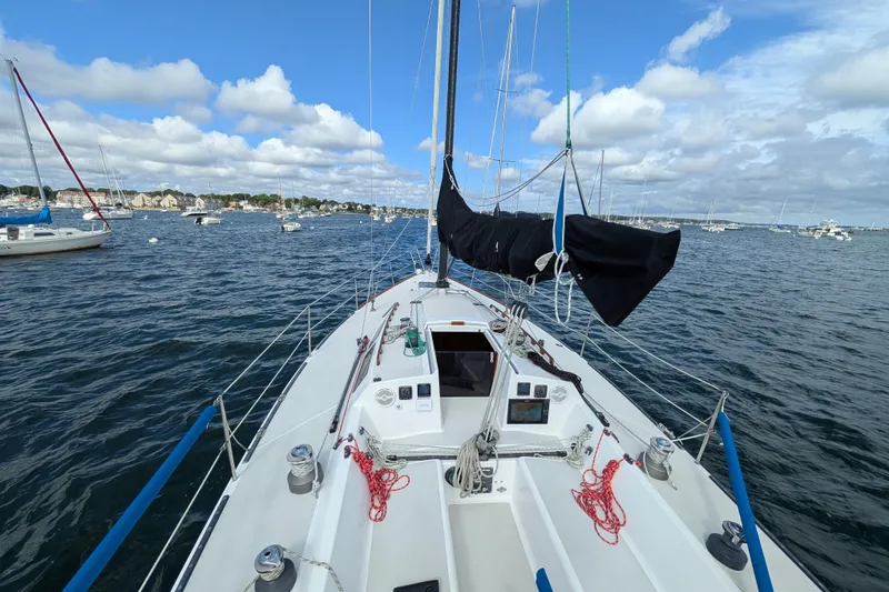 Slide: The Image of Sailboat on water, Express 37 model, 1986, with clear sky and distant shoreline. - 13