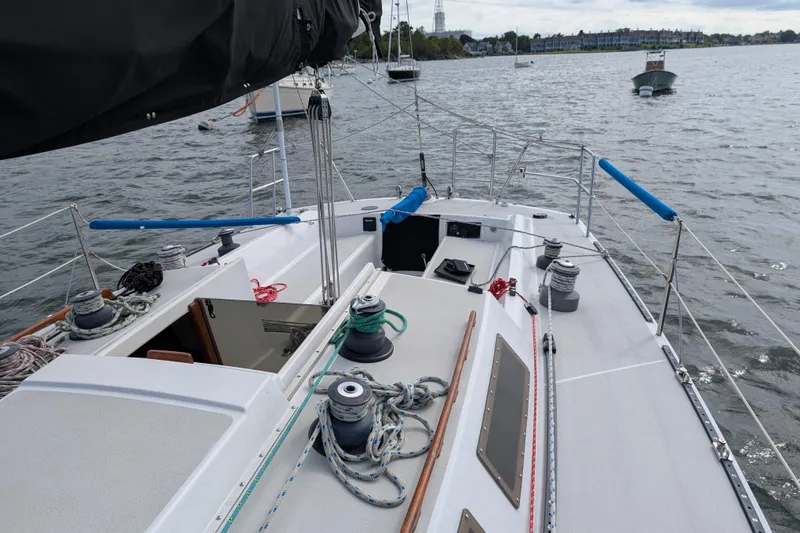 Slide: The Image of Sailboat deck view, Express 37 model, 1986, with ropes and winches on a calm waterway. - 15