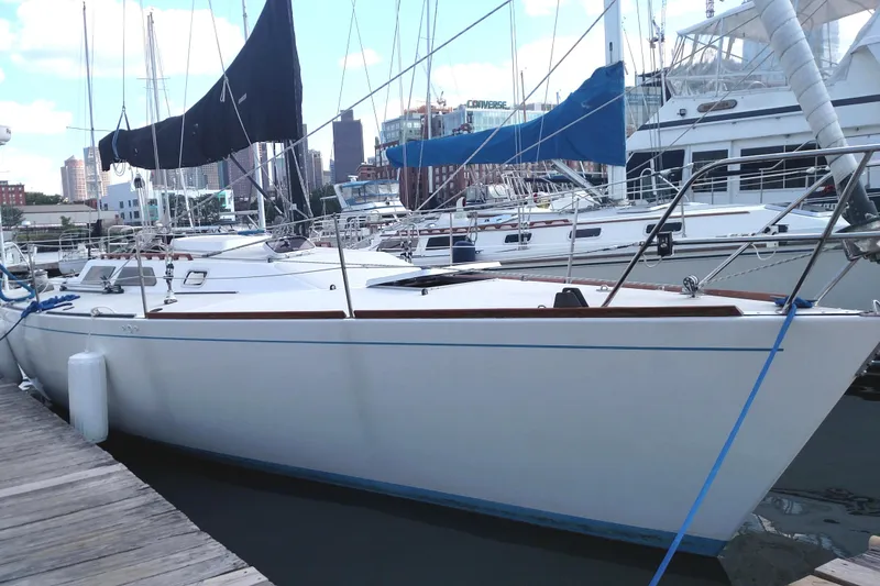 Slide: The Image of 1986 Express 37 sailboat docked at marina with city skyline in background. - 3