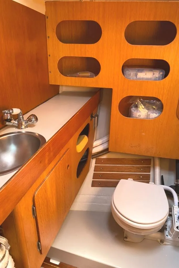 Slide: The Image of 1986 Express 37 yacht bathroom with wooden cabinetry, sink, and marine toilet. - 36