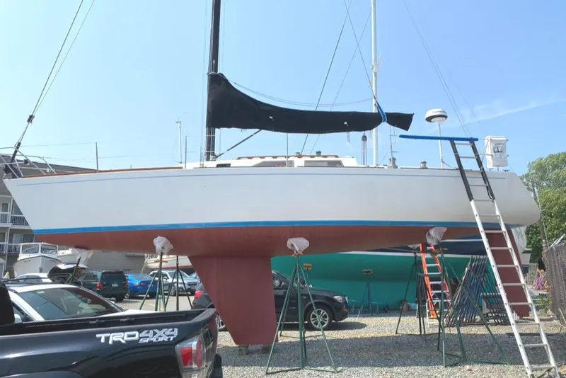 Slide: The Image of 1986 Express 37 sailboat on dry dock with black sail cover and red hull. - 6