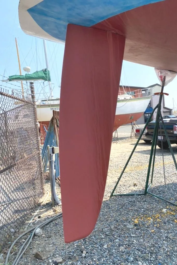 Slide: The Image of 1986 Express 37 sailboat keel in dry dock, surrounded by other boats and equipment. - 9