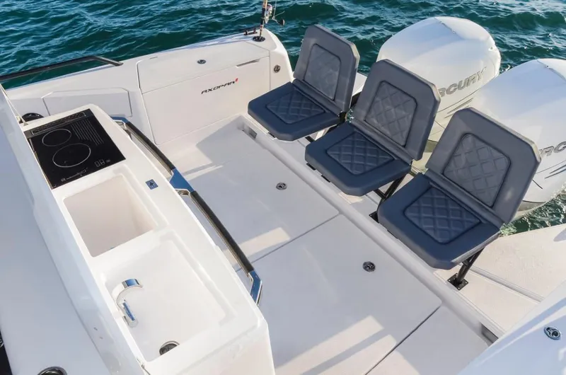 Slide: The Image of 2025 Axopar 37 Sun Top boat deck with seating and dual outboard engines. - 9