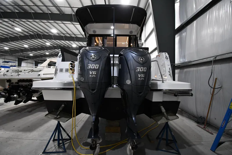 Slide: The Image of 2023 Jeanneau NC1095 boat with dual Yamaha 300 V6 engines in a storage facility. - 10