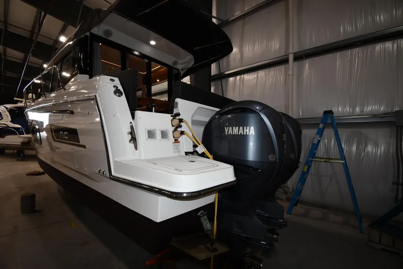 Slide: The Image of 2023 Jeanneau NC1095 boat with Yamaha outboard motor in a storage facility. - 11