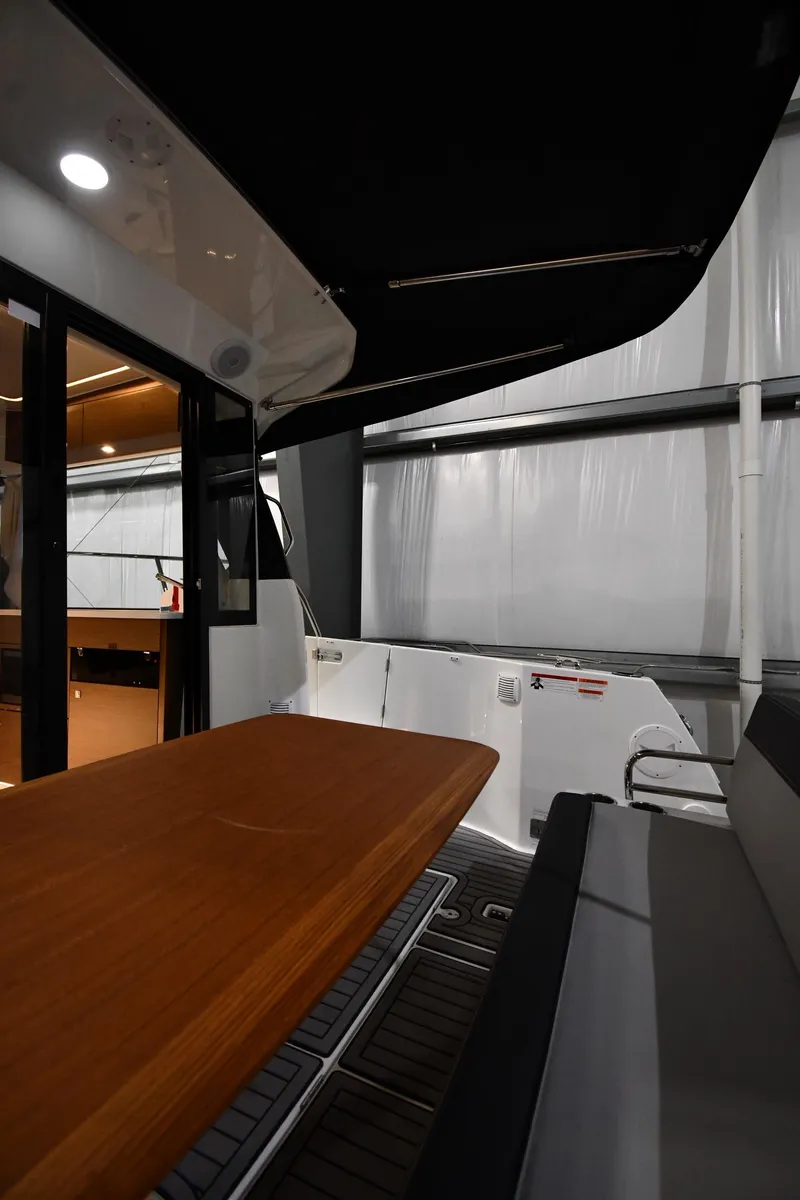 Slide: The Image of 2023 Jeanneau NC1095 boat interior with wooden table and seating area. - 21