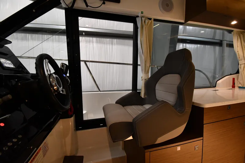 Slide: The Image of Interior of 2023 Jeanneau NC1095 boat showing helm seat and steering wheel. - 34
