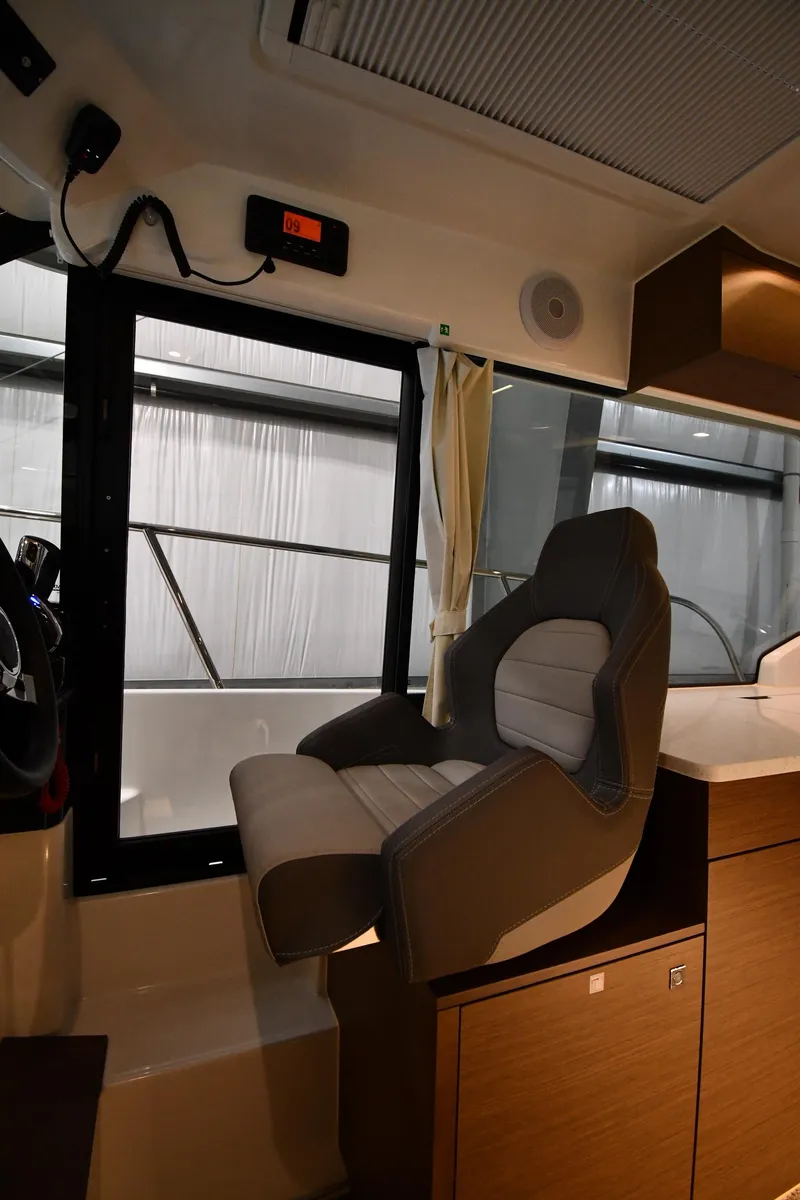 Slide: The Image of Interior of 2023 Jeanneau NC1095 boat with modern helm seat and window view. - 35