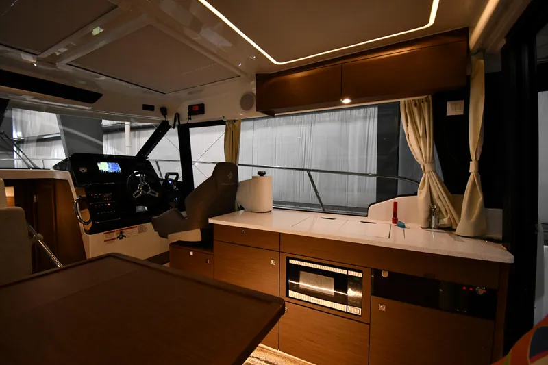 Slide: The Image of Interior of 2023 Jeanneau NC1095 boat with modern helm and kitchenette. - 36