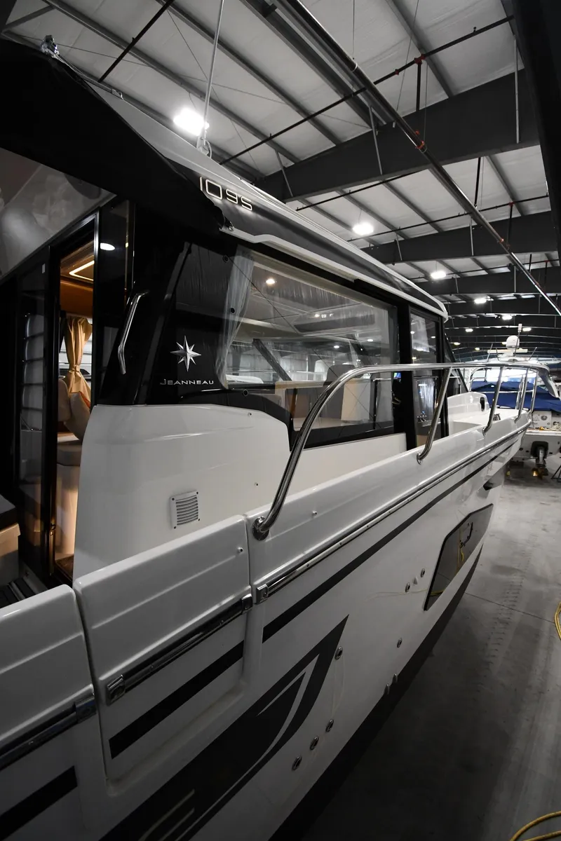 Slide: The Image of 2023 Jeanneau NC1095 boat in a showroom, showcasing sleek design and modern features. - 7