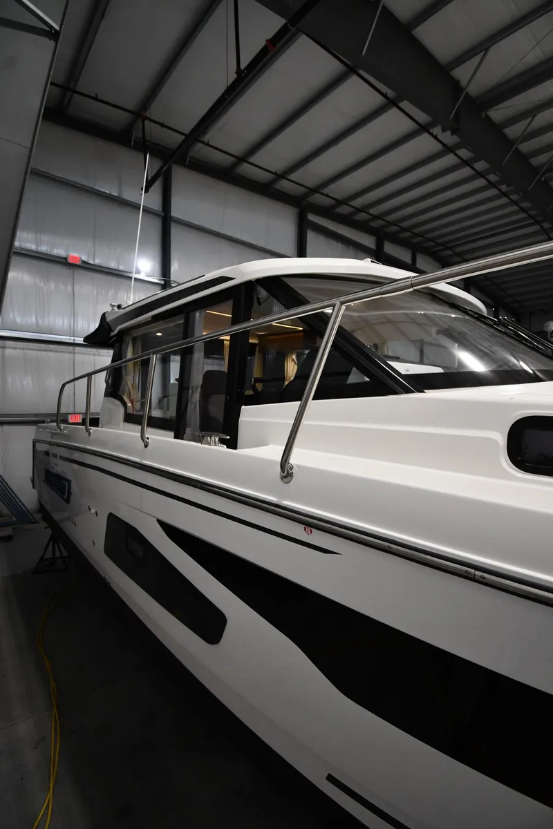 Slide: The Image of 2023 Jeanneau NC1095 boat in a warehouse, showcasing sleek design and modern features. - 8