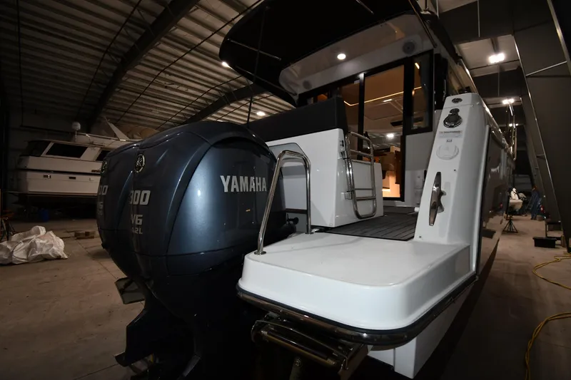 Slide: The Image of 2023 Jeanneau NC1095 boat with Yamaha engines in a storage facility. - 9