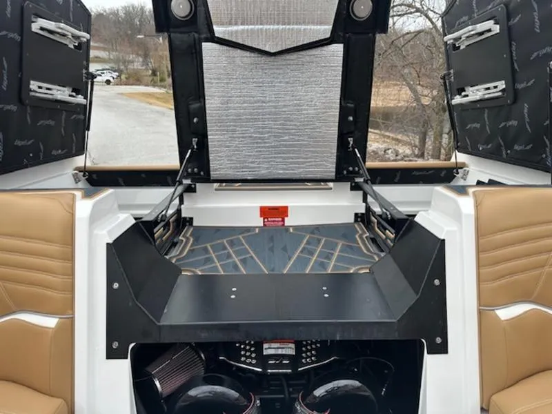 Slide: The Image of 2025 Tigé Ultré 25ZX boat interior with open engine compartment, showcasing modern design and seating. - 16