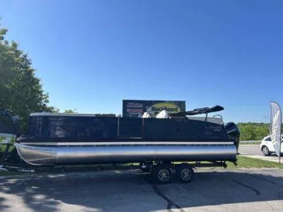 The Image of 2025 Lowe SS 250 Walk Thru pontoon boat on trailer, parked outdoors under clear blue sky. - 0