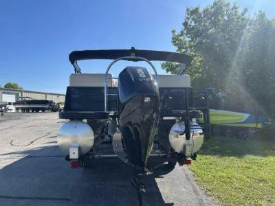 Slide: The Image of 2025 Lowe SS 250 Walk Thru pontoon boat with powerful outboard motor, parked outdoors. - 2