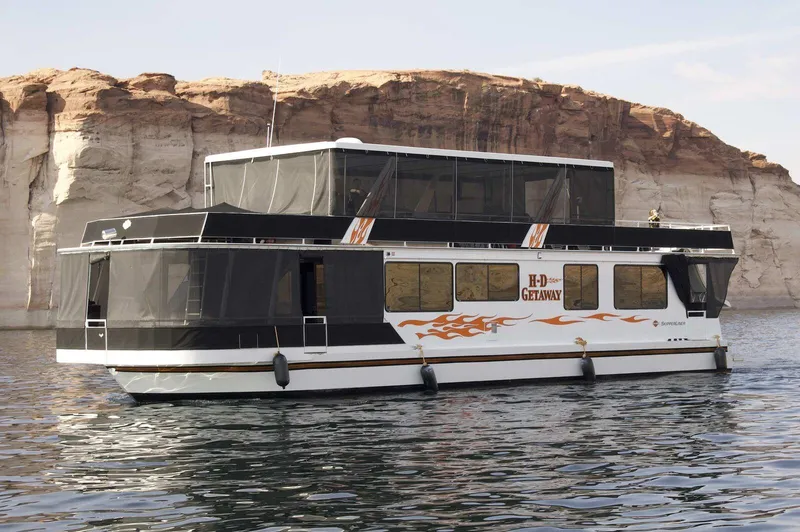 The Image of 1996 Skipperliner 61x16 Houseboat on calm water with rocky cliffs in the background. - 0