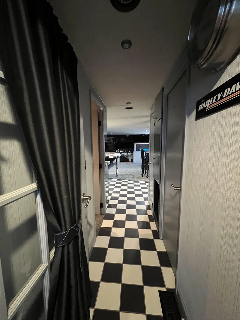 Slide: The Image of Hallway of a 1996 Skipperliner 61x16 Houseboat with checkered flooring and dark curtains. - 16