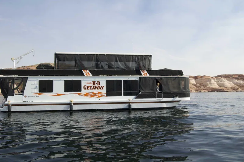 Slide: The Image of 1996 Skipperliner 61x16 Houseboat on water, featuring "H-D Getaway" branding. - 2