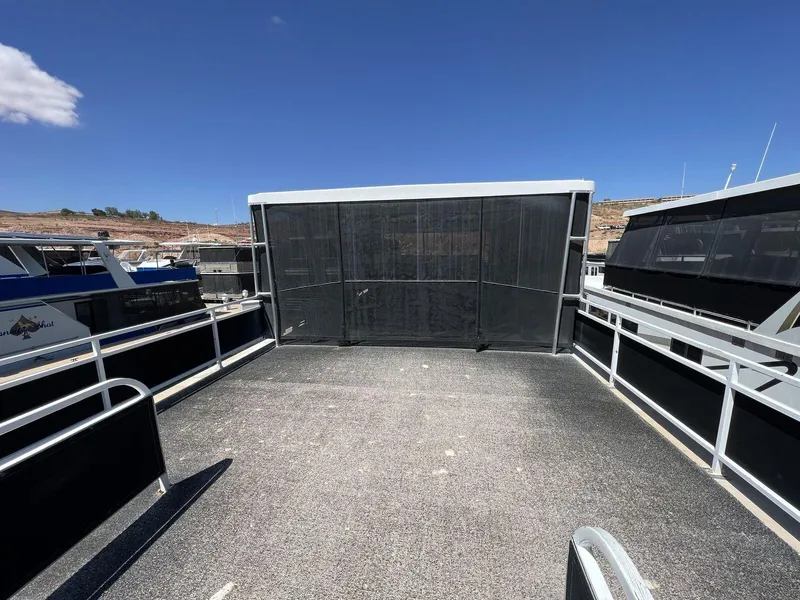 Slide: The Image of 1996 Skipperliner 61x16 Houseboat deck with railing, docked under clear blue sky. - 22