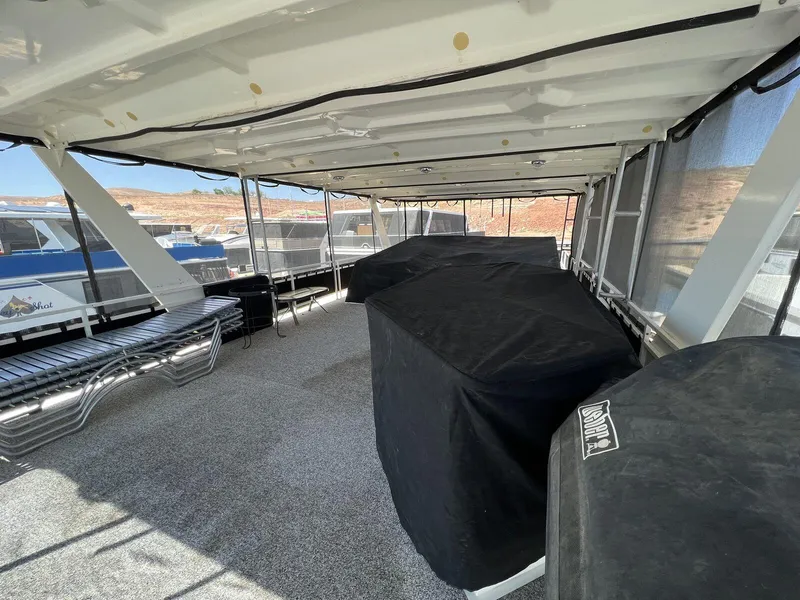 Slide: The Image of 1996 Skipperliner 61x16 Houseboat deck with covered seating and scenic views. - 24