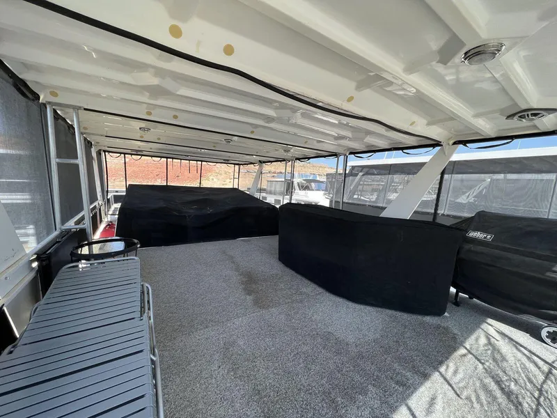 Slide: The Image of 1996 Skipperliner 61x16 Houseboat interior with covered seating and spacious deck area. - 25