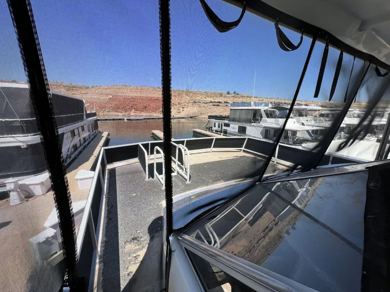 Slide: The Image of 1996 Skipperliner 61x16 Houseboat docked, featuring spacious deck and scenic marina view. - 26