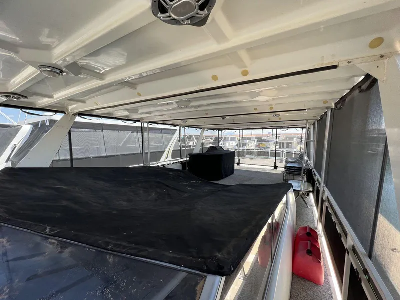 Slide: The Image of 1996 Skipperliner 61x16 Houseboat interior with covered seating area and open windows. - 27