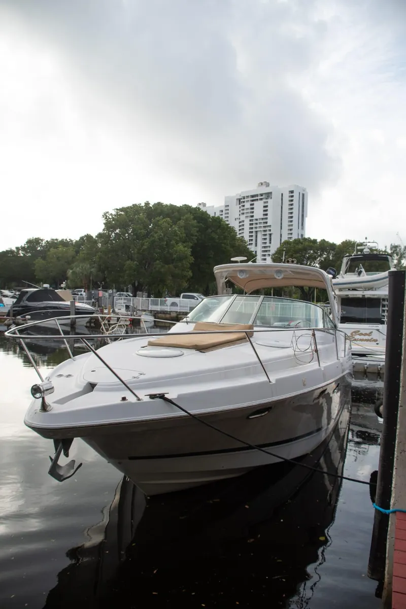 Slide: The Image of 2005 Four Winns 378 Vista yacht docked in a marina with cityscape background. - 2