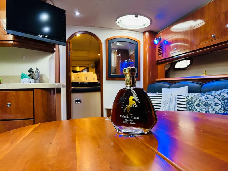 Slide: The Image of Luxurious 2005 Four Winns 378 Vista yacht interior with elegant wooden table and premium liquor bottle. - 31