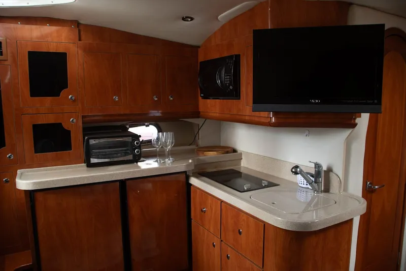 Slide: The Image of 2005 Four Winns 378 Vista yacht kitchen with wood cabinets, sink, and appliances. - 36