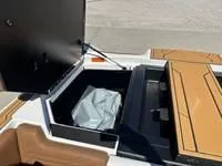 Slide: The Image of 2025 ATX Surf Boats 24 Type-S storage compartment with open lid and interior view. - 10
