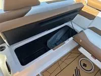 Slide: The Image of 2025 ATX Surf Boats 24 Type-S interior storage compartment with brown and white seating. - 13