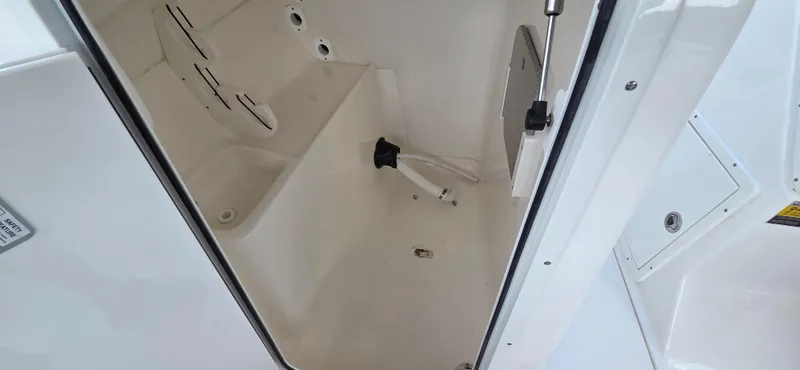 Slide: The Image of 2024 Key West 239 DFS boat interior storage compartment, white and spacious design. - 10