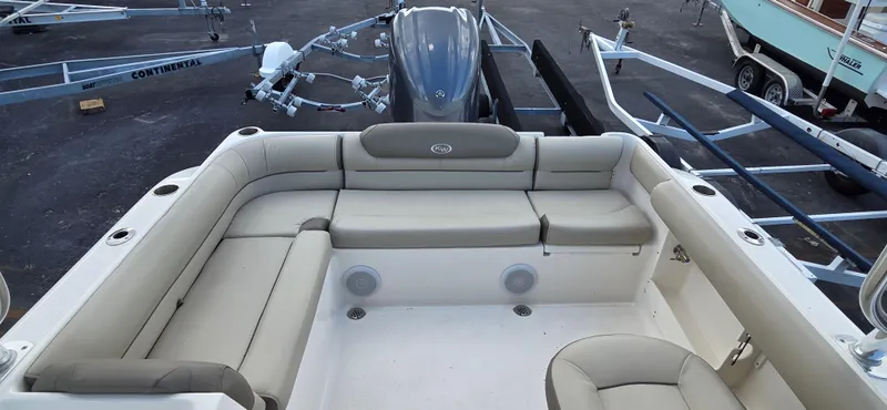 Slide: The Image of 2024 Key West 239 DFS boat interior with beige seating and motor in a marina. - 12