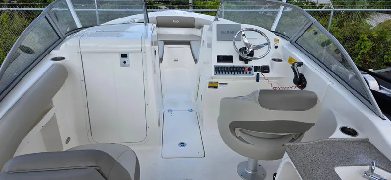 Slide: The Image of 2024 Key West 239 DFS boat interior with steering wheel and seating. - 9