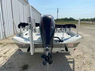 Slide: The Image of 2019 Crestliner 2000 Bay boat with motor, parked outdoors near a metal building. - 5