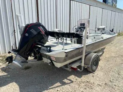 Slide: The Image of 2019 Crestliner 2000 Bay boat with outboard motor on a trailer, parked outdoors. - 6